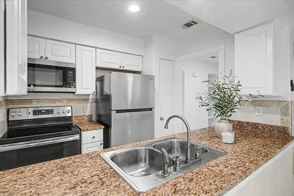a kitchen with sink a stove and refrigerator