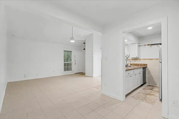 a kitchen with granite countertop white cabinets and white appliances