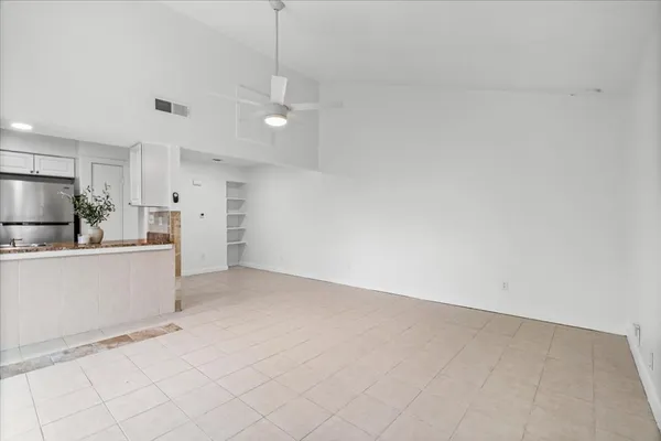 a view of a kitchen with refrigerator and white cabinets