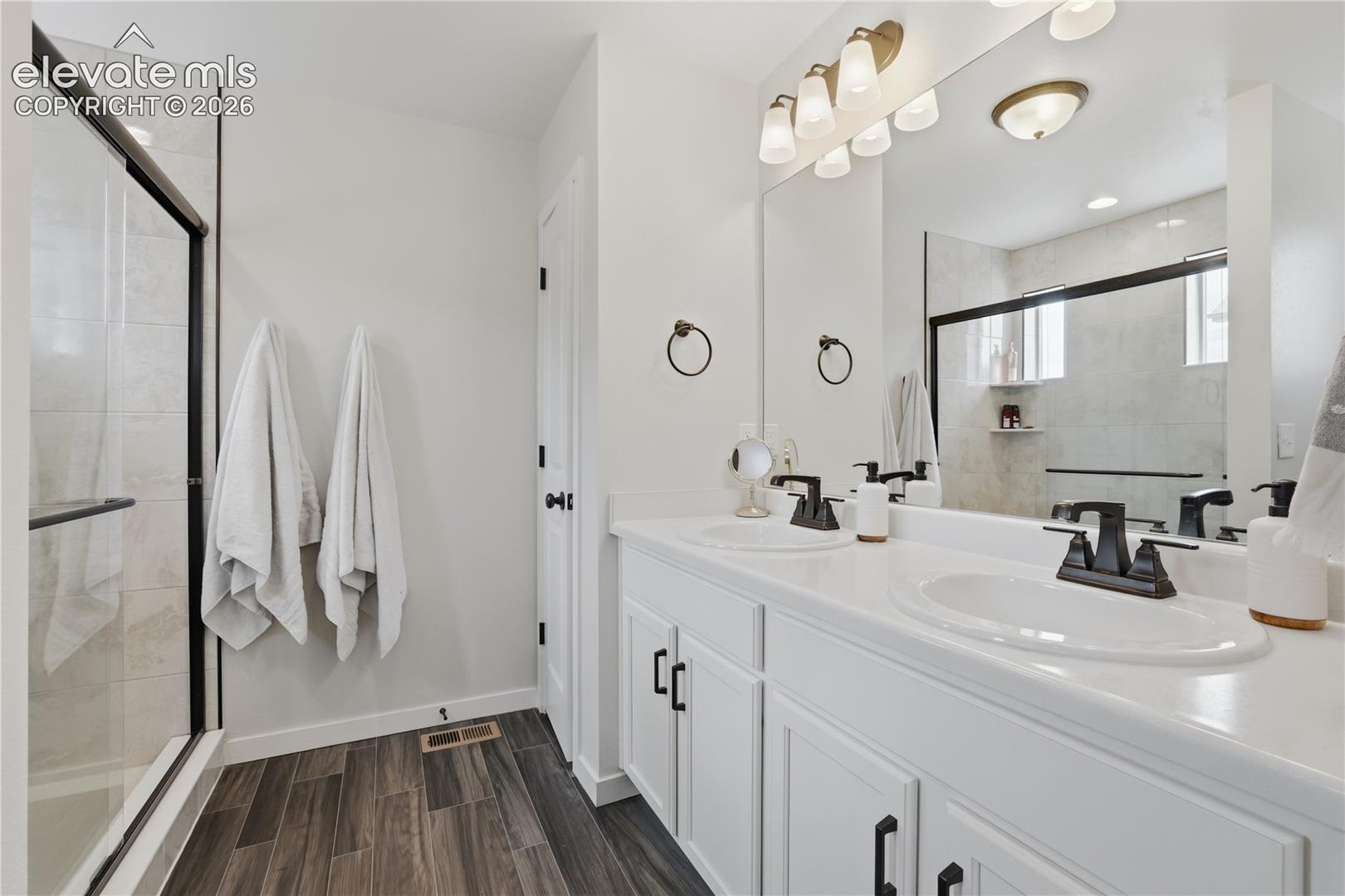 6008 Ashmore Road Colorado Springs, CO 80927 - Photo 22 of 48 Dual vanity with white cabinetry and solid surface countertops