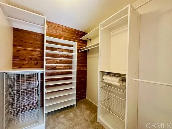 a view of walk in closet with empty racks