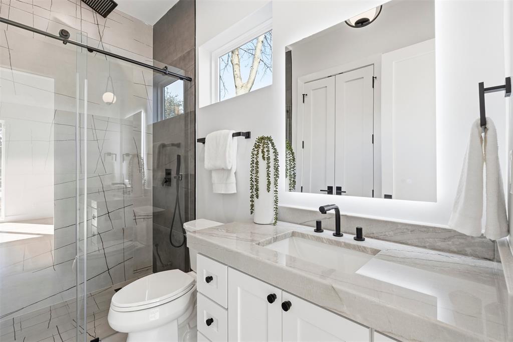 6257 Turner Way Dallas, TX 75230 - Photo 23 of 39 a bathroom with a granite countertop sink a toilet a mirror and shower