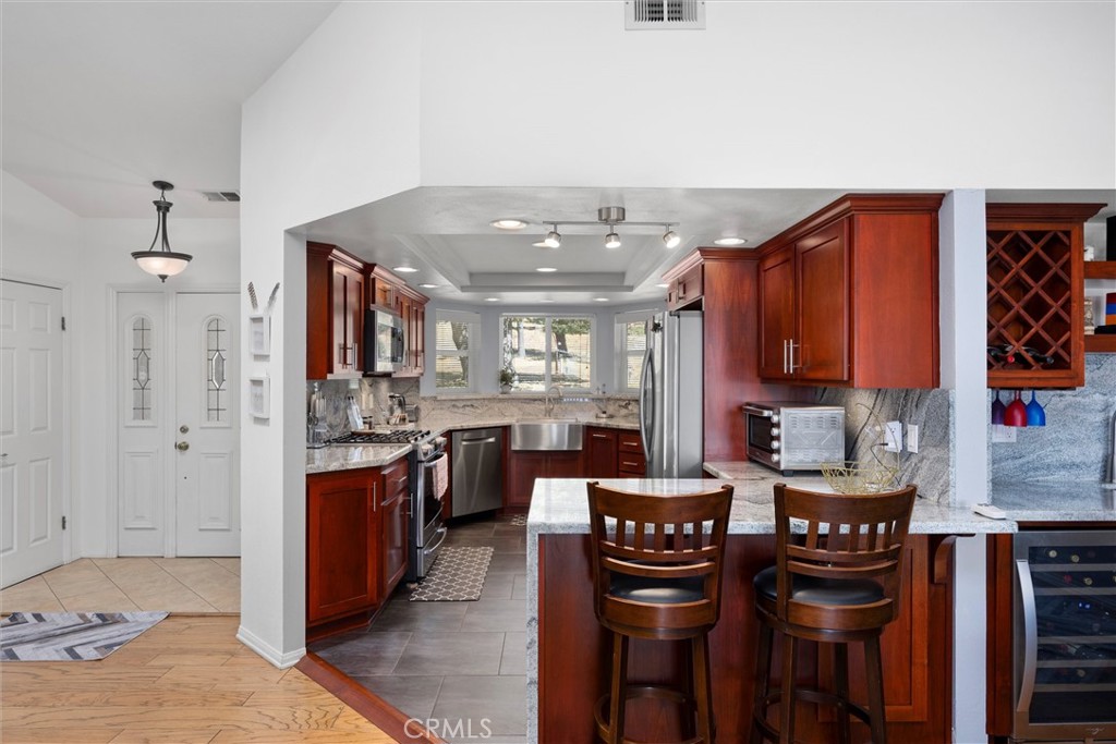 26511 Teal Court Tehachapi, CA 93561 - Photo 19 of 68 a kitchen with stainless steel appliances kitchen island granite countertop a sink and cabinets