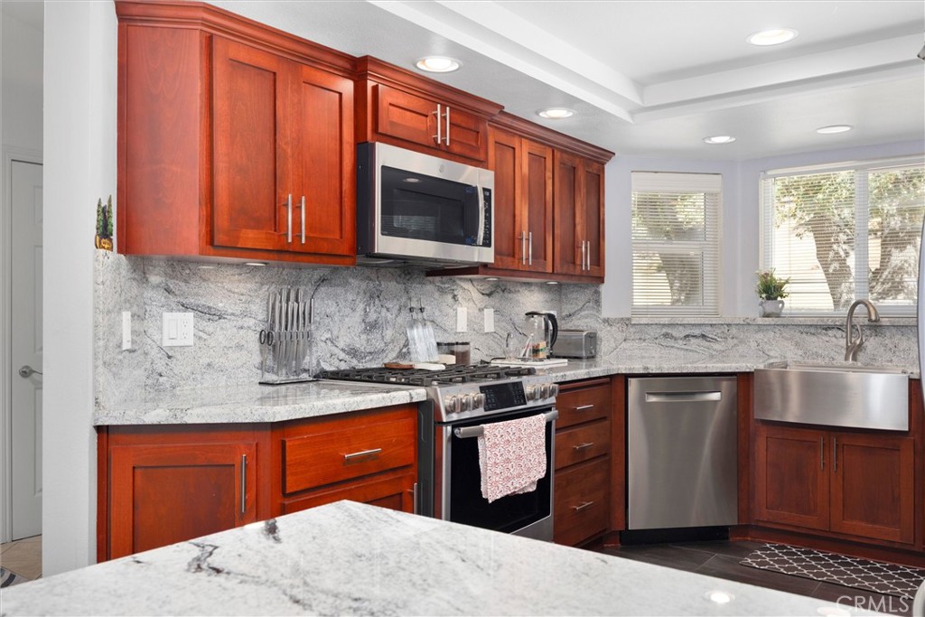 26511 Teal Court Tehachapi, CA 93561 - Photo 21 of 68 a kitchen with stainless steel appliances granite countertop wooden cabinets a sink and a stove