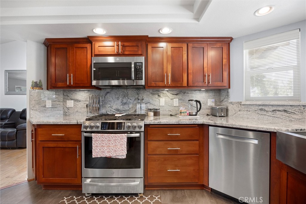 26511 Teal Court Tehachapi, CA 93561 - Photo 23 of 68 a kitchen with stainless steel appliances granite countertop a stove a sink and a microwave