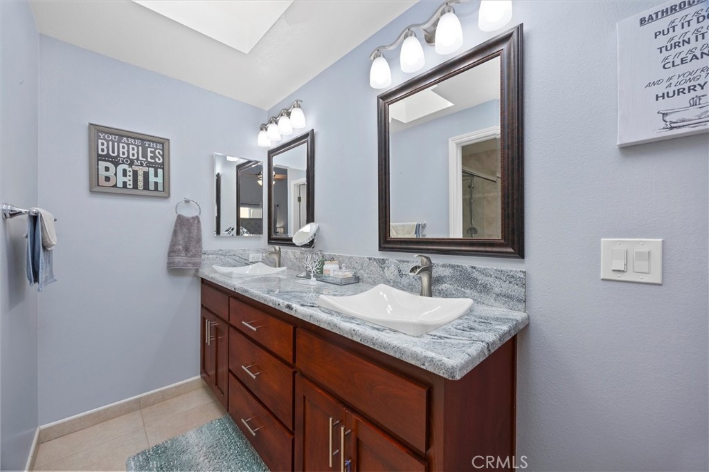 26511 Teal Court Tehachapi, CA 93561 - Photo 34 of 68 a bathroom with a granite countertop sink and a mirror