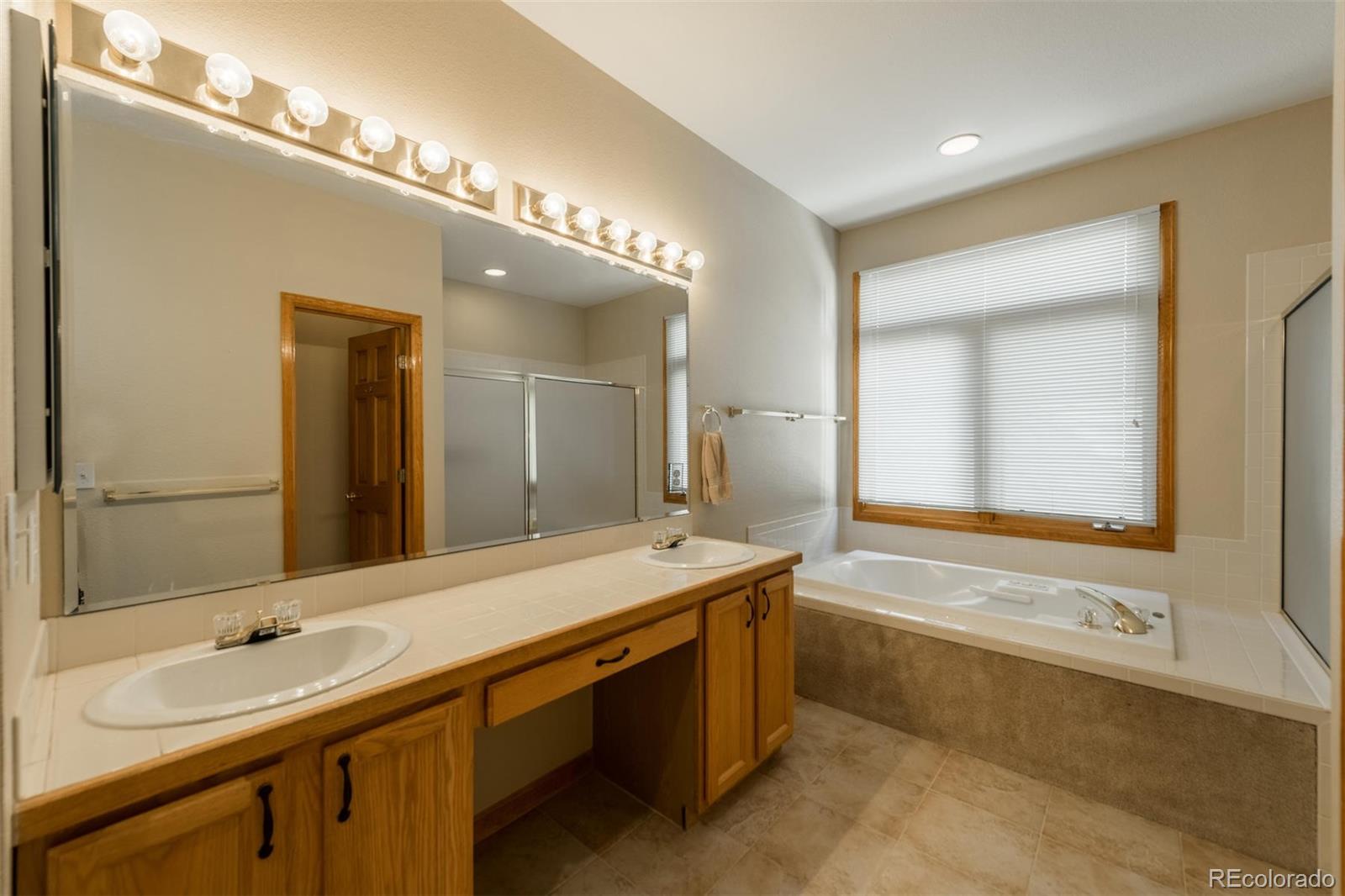 14 Hathaway Lane Highlands Ranch, CO 80130 - Photo 19 of 29 a spacious bathroom with a tub double sink and mirror
