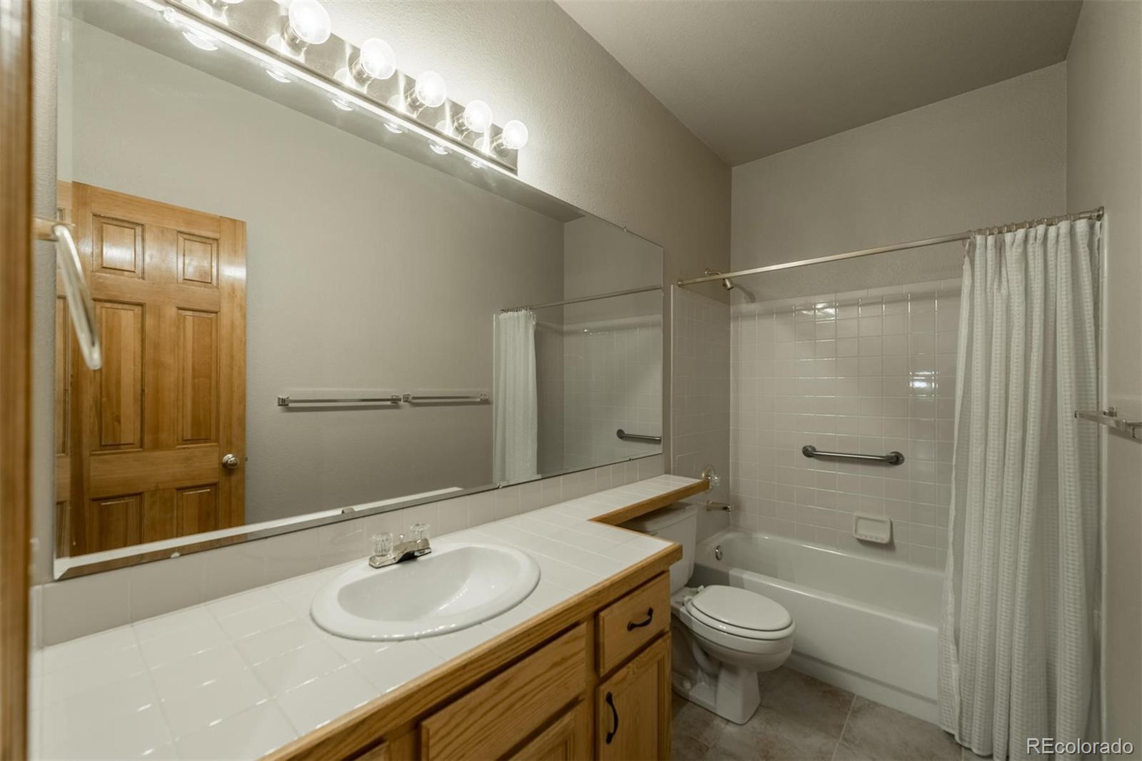 14 Hathaway Lane Highlands Ranch, CO 80130 - Photo 22 of 29 a bathroom with a granite countertop sink toilet a shower and a mirror