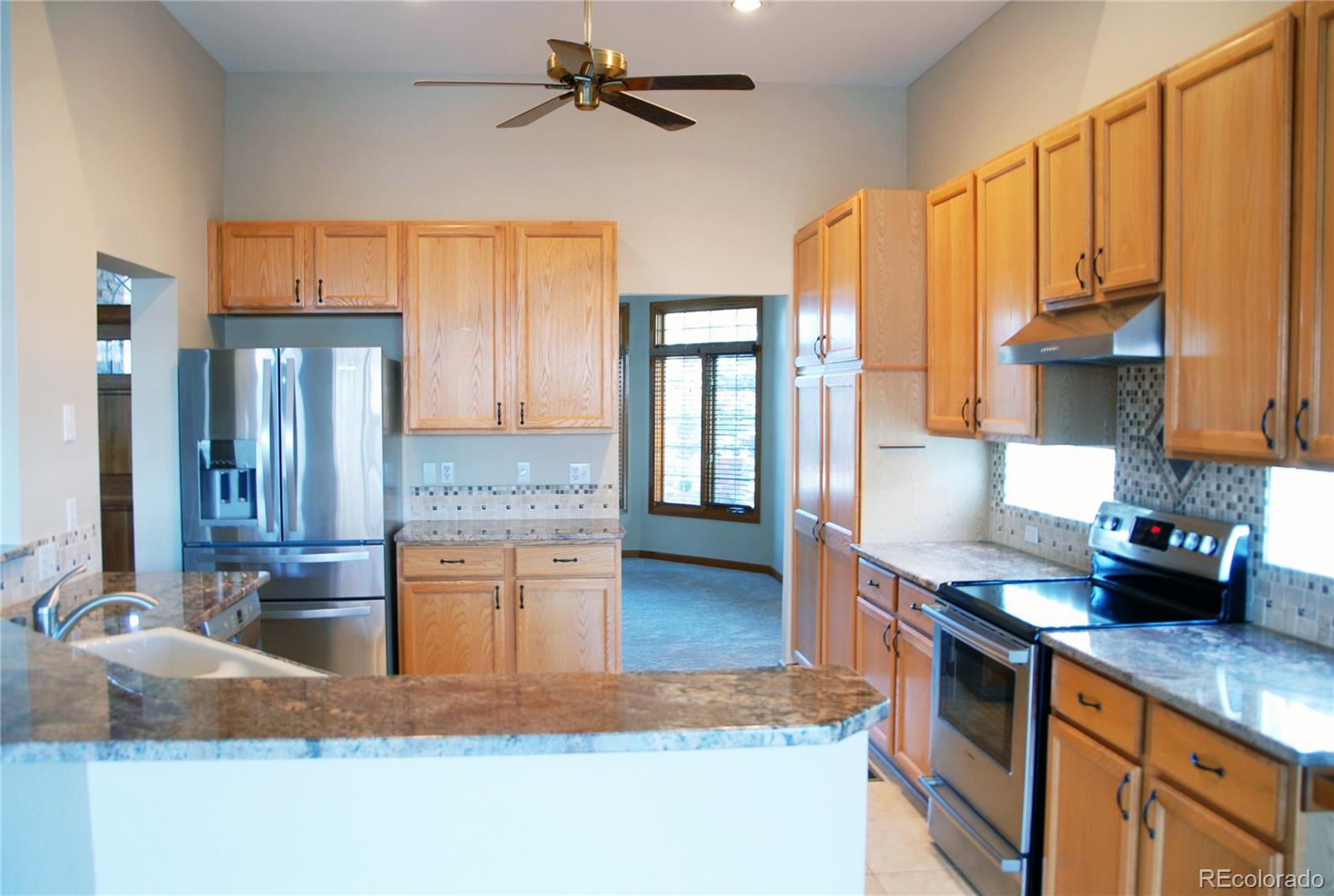14 Hathaway Lane Highlands Ranch, CO 80130 - Photo 8 of 29 a kitchen with kitchen island granite countertop a sink cabinets and wooden floor