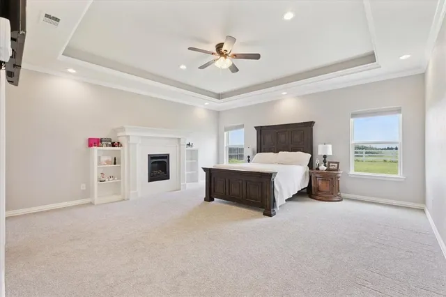 a spacious bedroom with a bed a window and a ceiling fan