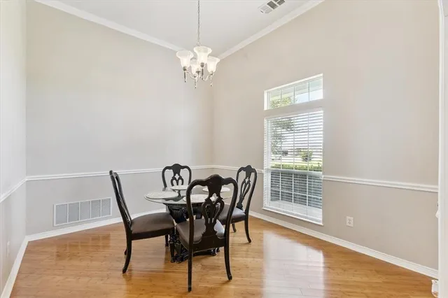 a view of a dining room with furniture wooden floor and chandelier