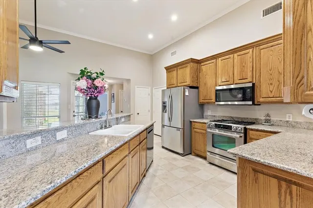 a kitchen with granite countertop a sink stove and refrigerator