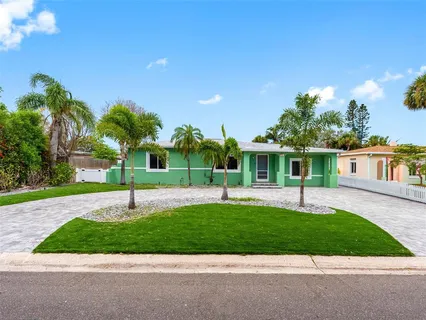 a front view of a house with a garden and yard