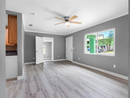 a view of an empty room with a window and wooden floor