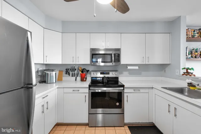 a kitchen with granite countertop white cabinets and white appliances