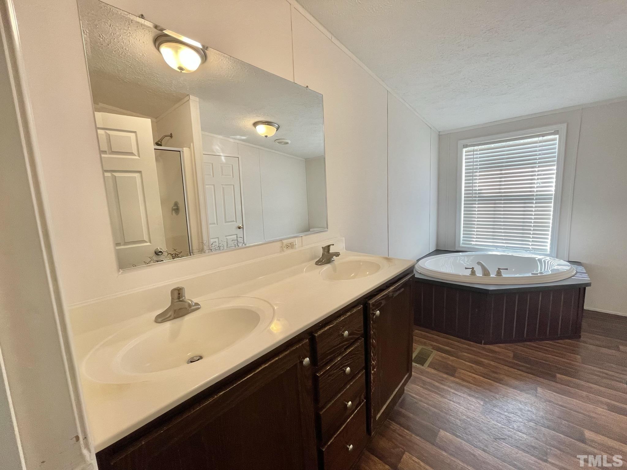45 Divine Lane Roxboro, NC 27573 - Photo 13 of 28 a spacious bathroom with a double vanity sink a mirror and a bathtub