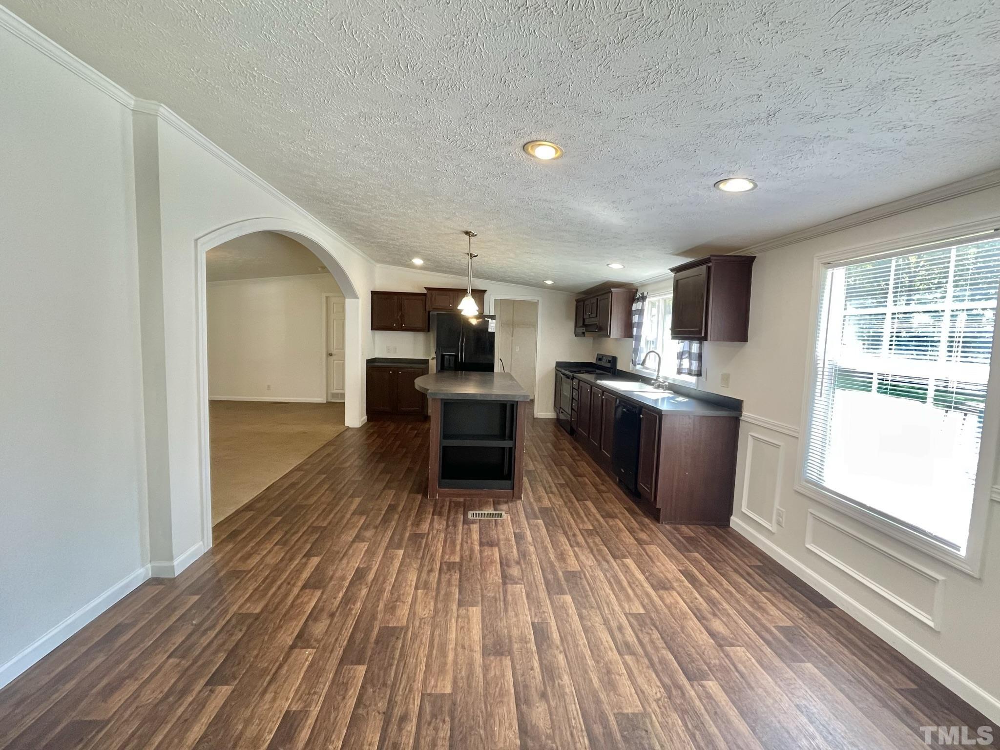 45 Divine Lane Roxboro, NC 27573 - Photo 7 of 28 a kitchen with stainless steel appliances granite countertop a refrigerator a stove top oven and wooden floor