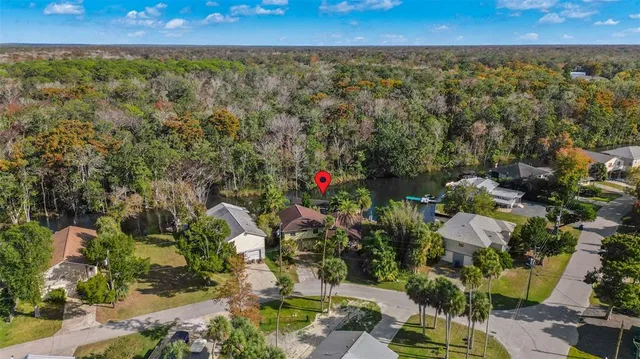 an aerial view of residential house with outdoor space and trees all around
