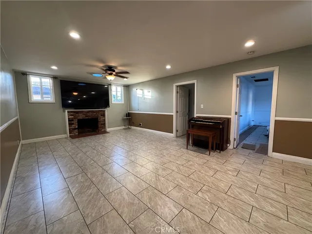 a view of a refrigerator in kitchen and an empty room