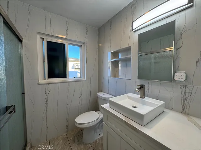 a bathroom with a granite countertop toilet and sink