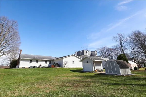 a view of a big house with a big yard and large trees