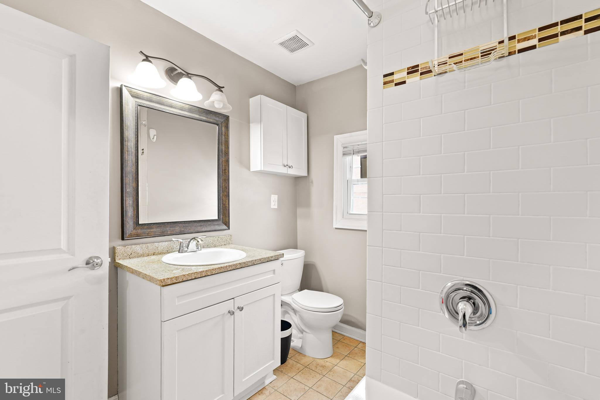 5013 The Alameda Baltimore, MD 21239 - Photo 17 of 24 a bathroom with a granite countertop sink toilet a mirror and shower