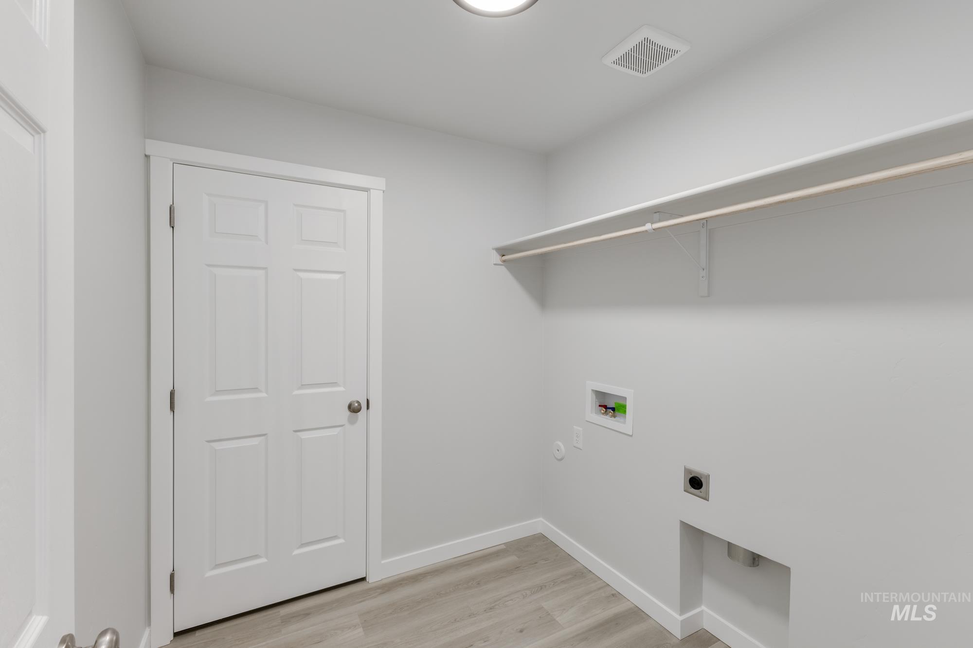 1716 North Birch Street Jerome, ID 83338 - Photo 12 of 16 Washroom with light wood-type flooring, hookup for a washing machine, electric dryer hookup, and hookup for a gas dryer