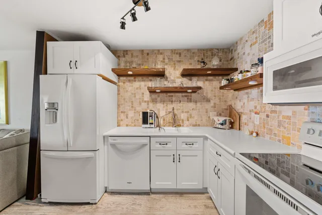 a kitchen with cabinets and white appliances