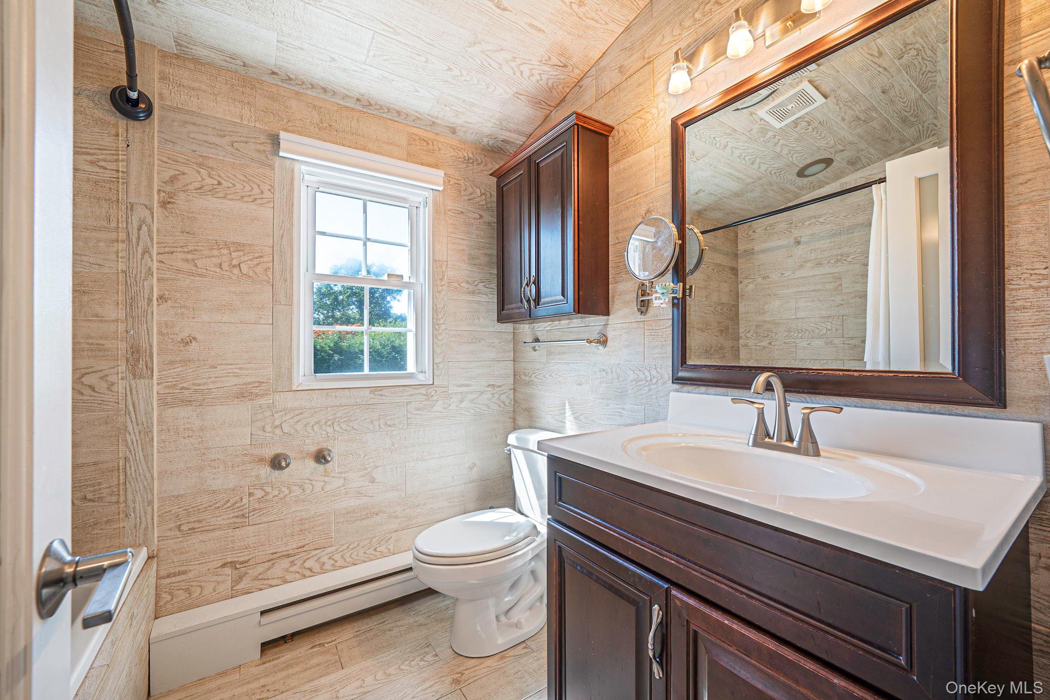 183 Old Country Road Speonk, NY 11972 - Photo 11 of 48 Bathroom featuring vanity, baseboard heating, and light wood finished floors