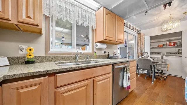 a kitchen with stainless steel appliances granite countertop sink window and cabinets