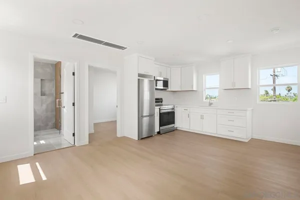 a kitchen with stainless steel appliances a refrigerator sink and cabinets