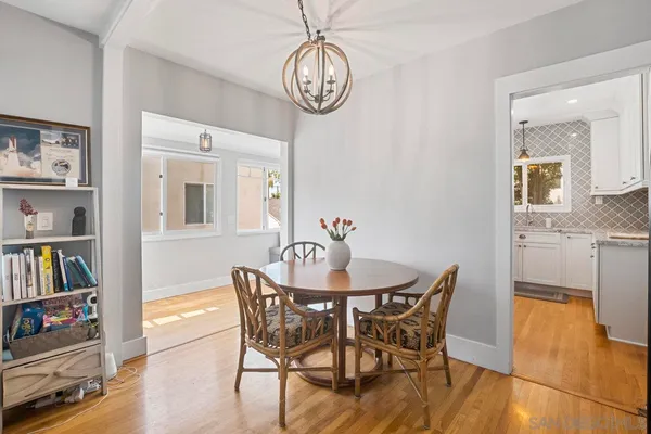 a view of a dining room with furniture a book and wooden floor