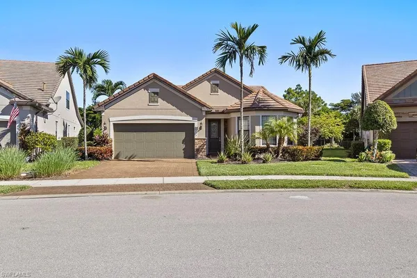 a front view of house with small garden and palm tree
