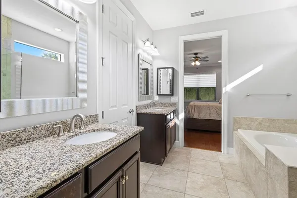 a bathroom with a granite countertop double vanity sink and a mirror