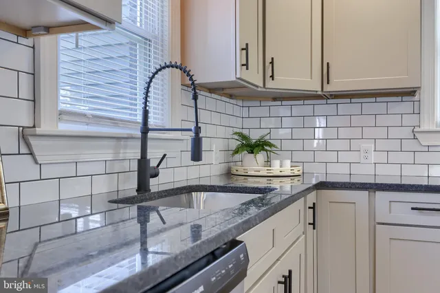 a kitchen with granite countertop a sink and cabinets