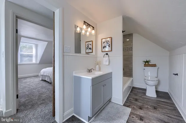 a bathroom with a toilet sink a mirror and a bathtub