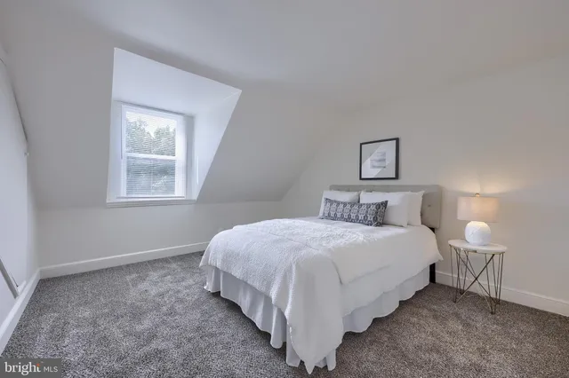 a bedroom with a bed lamp and a window