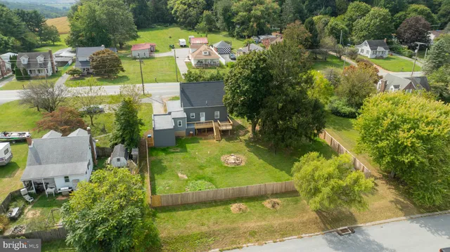 an aerial view of residential houses with outdoor space and trees