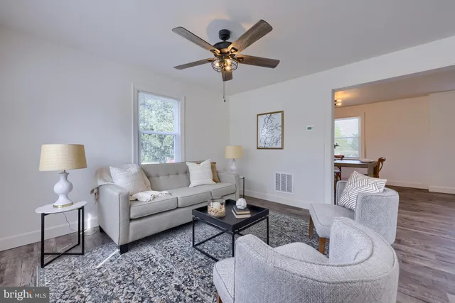 a living room with furniture and a ceiling fan