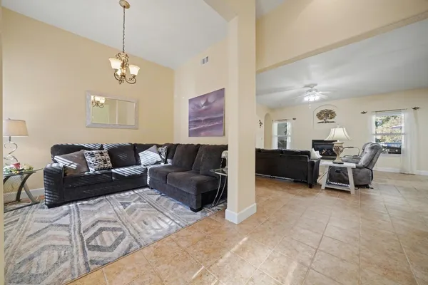 a living room with furniture a flat screen tv and a large window