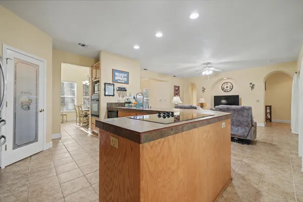 a bedroom with a bed a flat screen tv and a chandelier