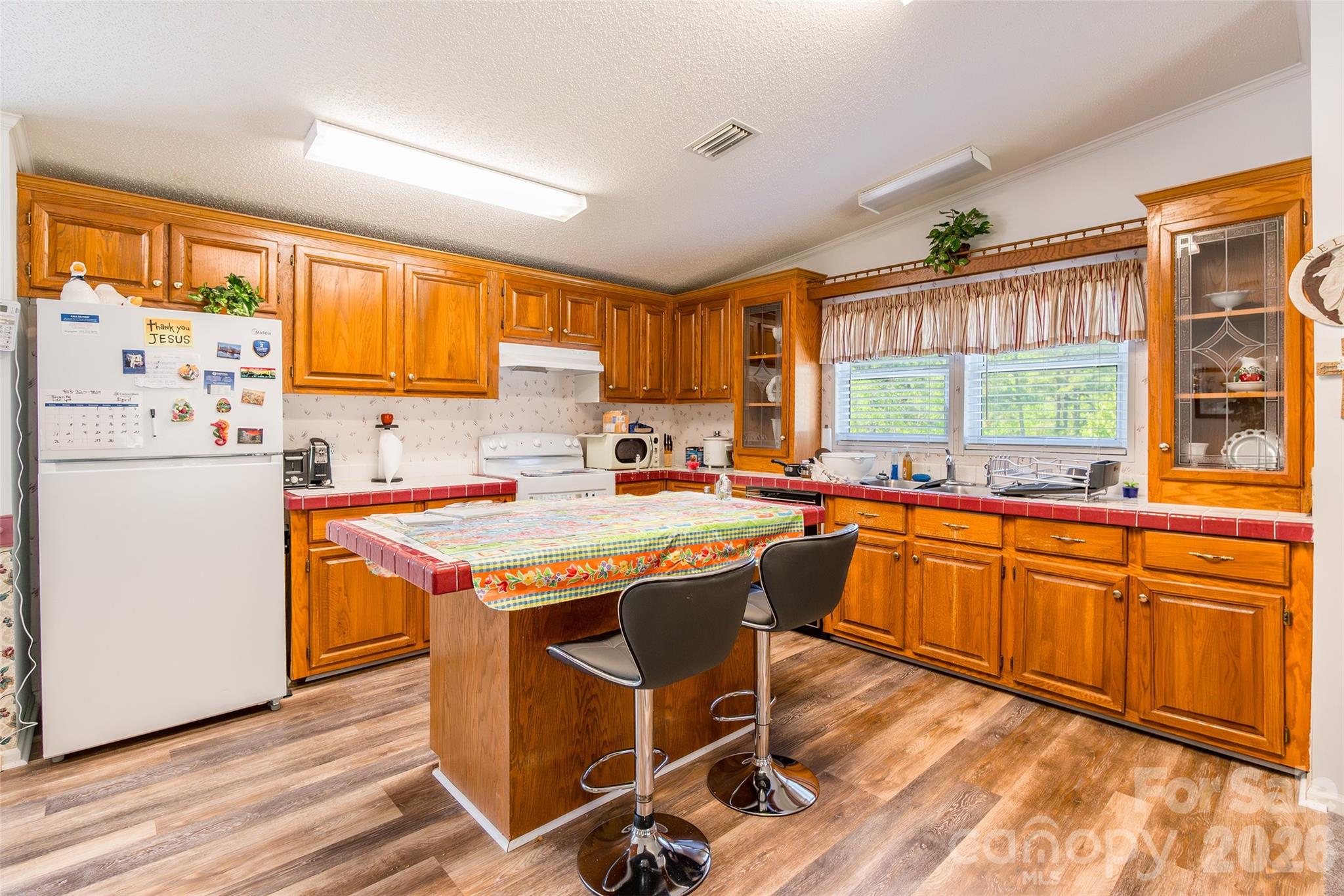 777 John Doster Road Pageland, SC 29728 - Photo 13 of 34 a kitchen with stainless steel appliances granite countertop a stove a refrigerator a sink dishwasher and a dining table with wooden cabinet