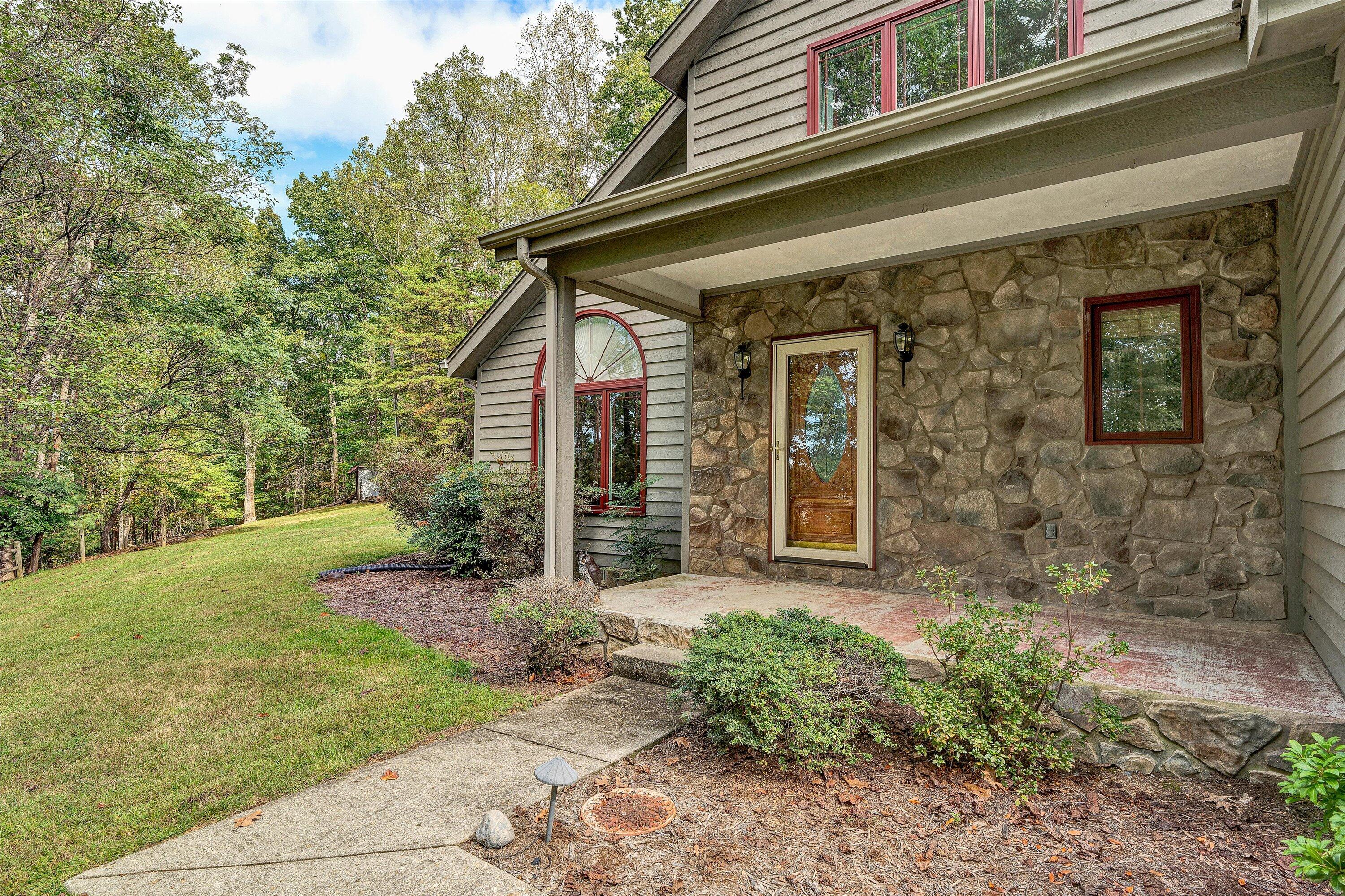29 Serenity Lane Blue Ridge, VA 24064 - Photo 58 of 81 a view of a house with brick walls and a yard with plants