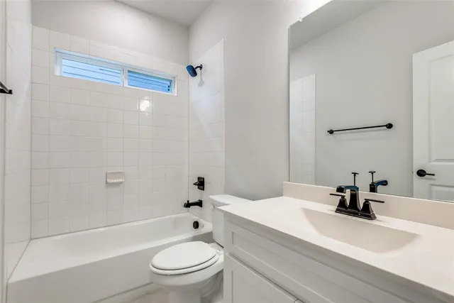 a bathroom with a sink a toilet a mirror and shower