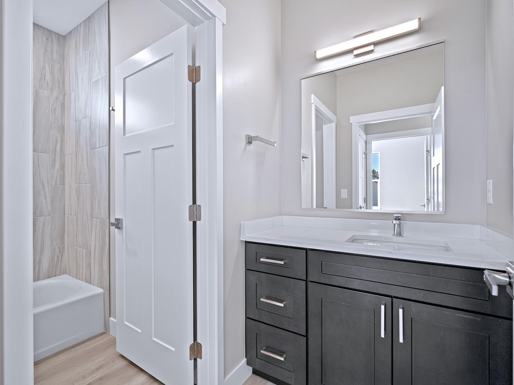 2952 Apollo Drive Grand Junction, CO 81504 - Photo 20 of 27 a bathroom with a granite countertop sink a mirror and a bathtub