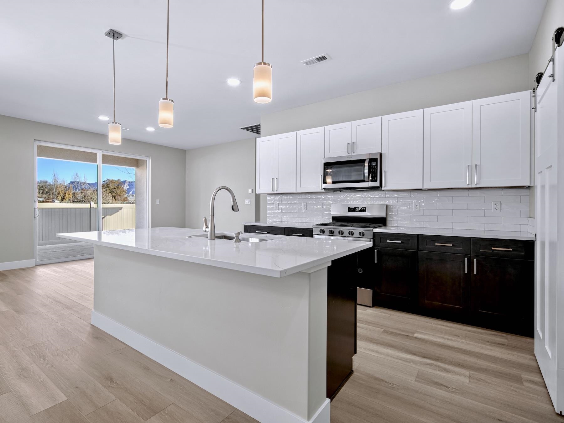 2952 Apollo Drive Grand Junction, CO 81504 - Photo 6 of 27 a kitchen with stainless steel appliances granite countertop a sink a stove a refrigerator and cabinets with wooden floor