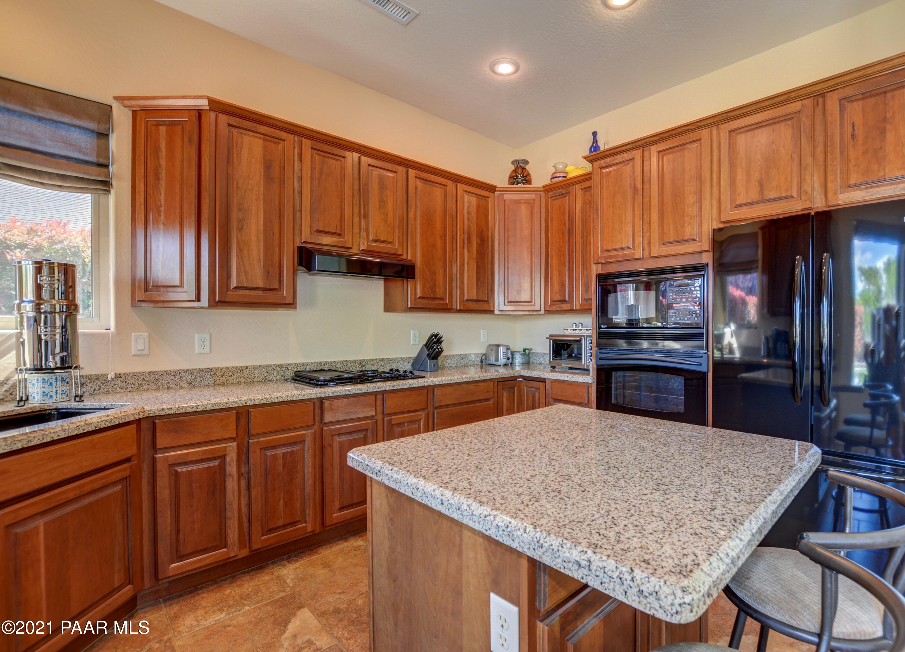 6582 Farmstead Road, Unit 3 Prescott Valley, AZ 86314 - Photo 12 of 41 a kitchen with stainless steel appliances wooden cabinets a stove a sink and a refrigerator