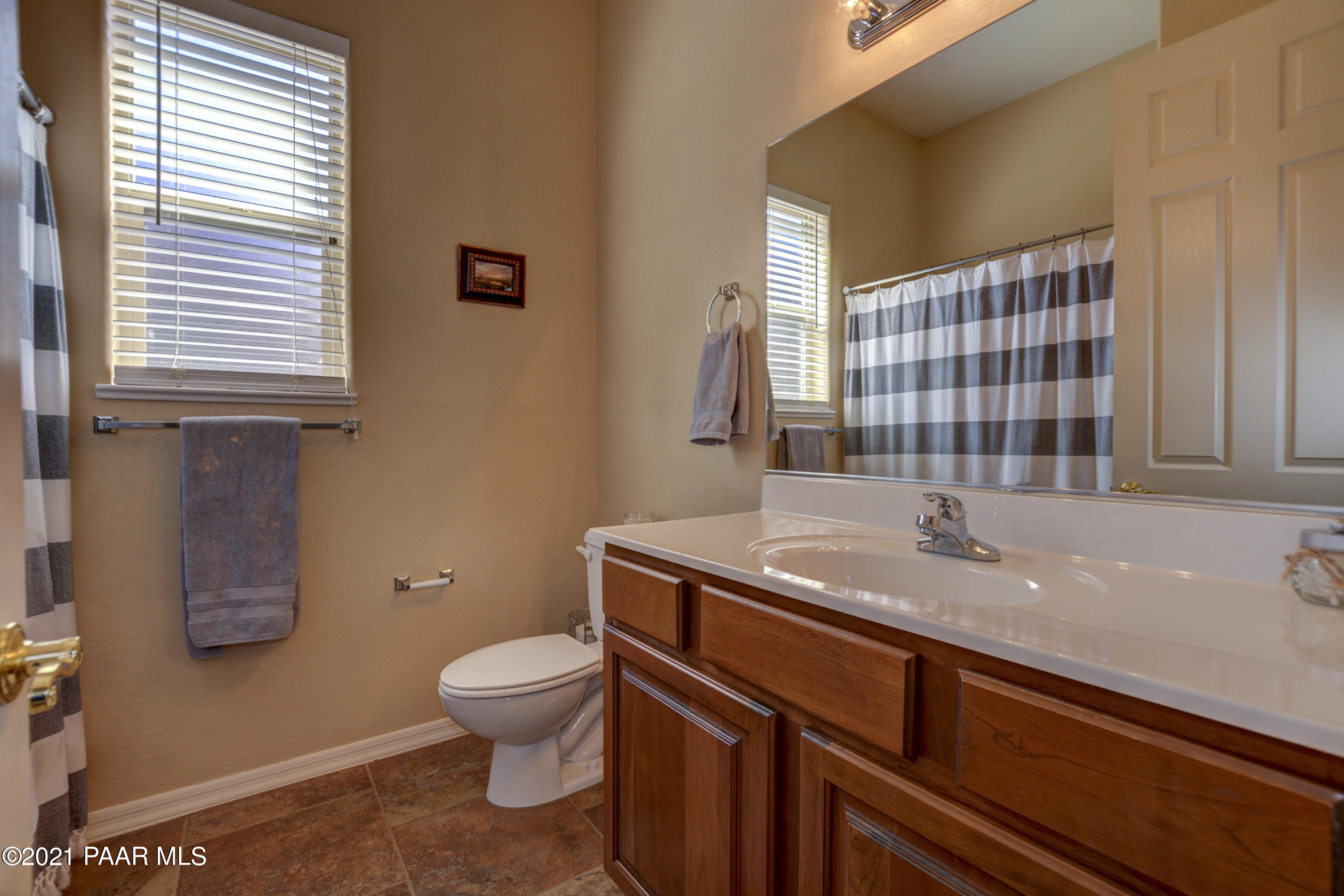 6582 Farmstead Road, Unit 3 Prescott Valley, AZ 86314 - Photo 20 of 41 a bathroom with a granite countertop sink toilet a mirror and shower