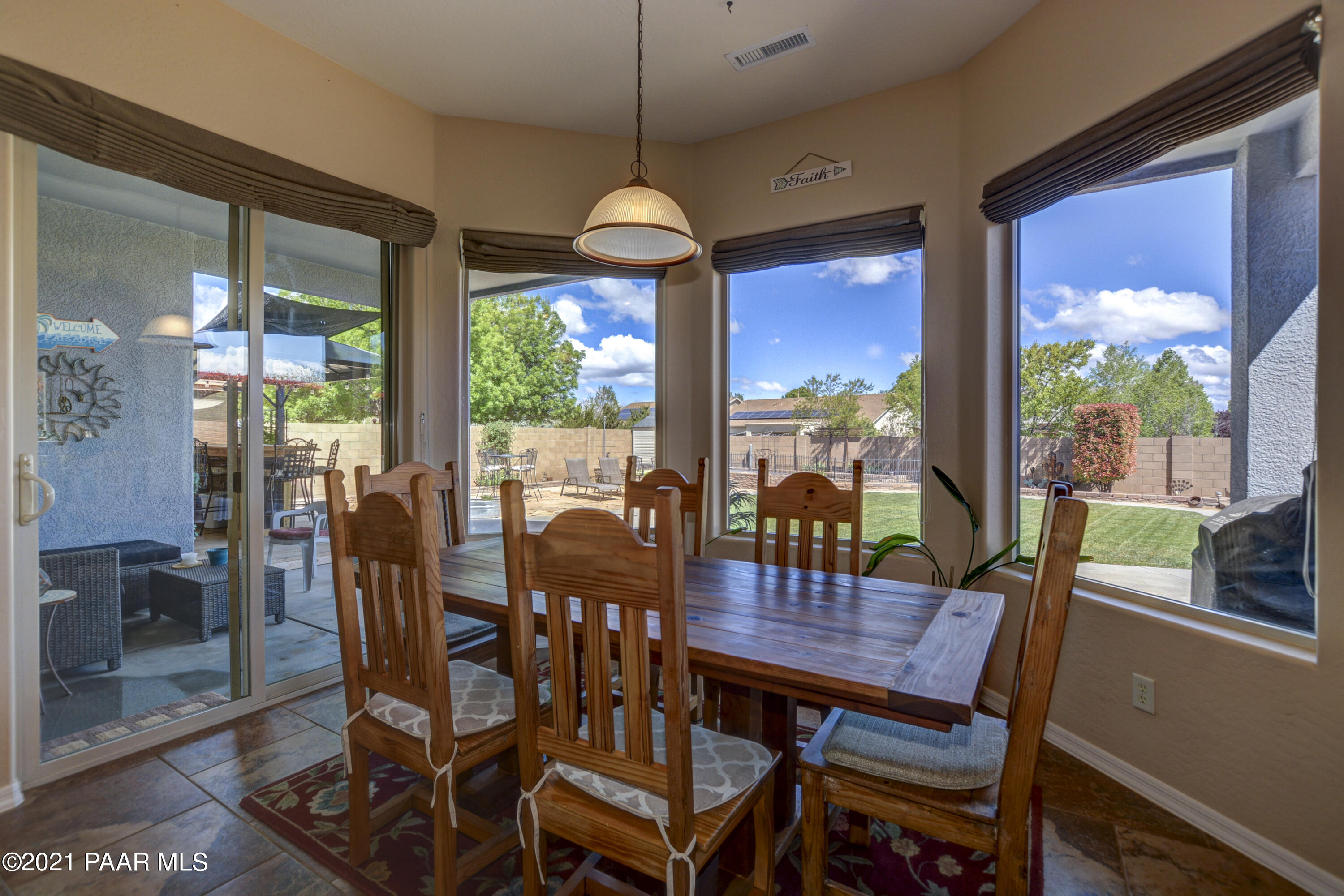 6582 Farmstead Road, Unit 3 Prescott Valley, AZ 86314 - Photo 8 of 41 a dining room with furniture a chandelier and glass door