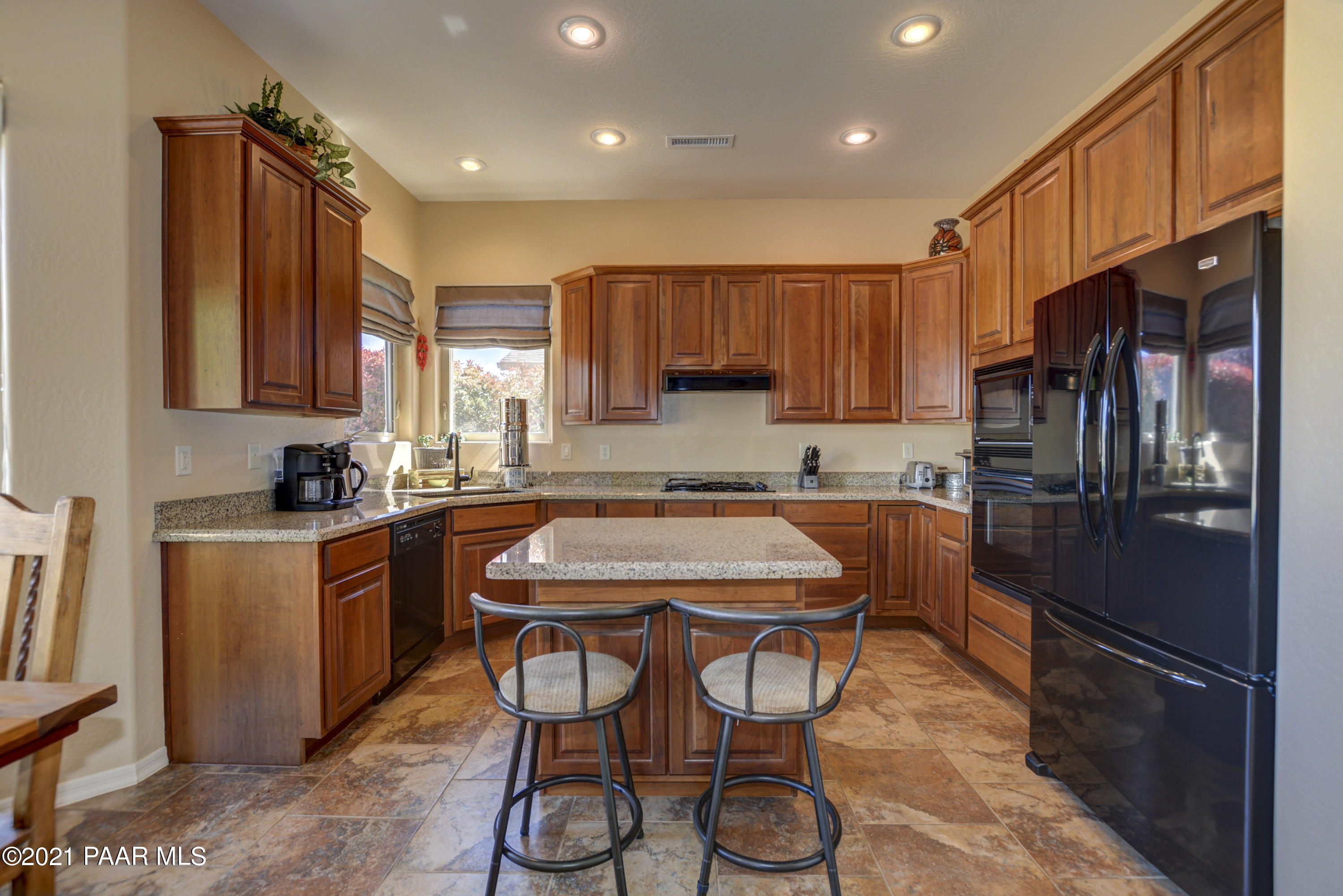 6582 Farmstead Road, Unit 3 Prescott Valley, AZ 86314 - Photo 10 of 41 a kitchen with stainless steel appliances granite countertop a refrigerator and a stove top oven